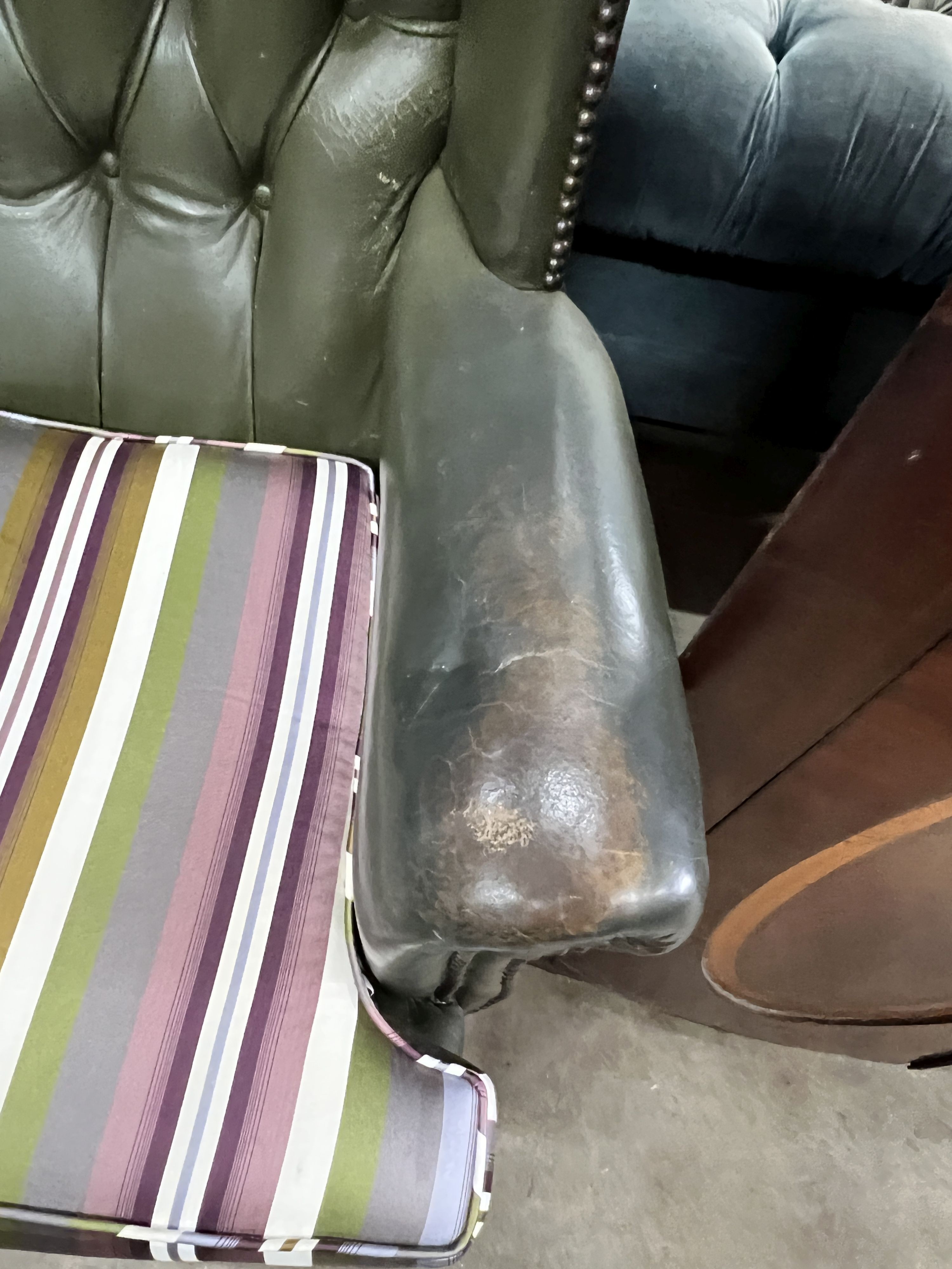 Two Victorian style buttoned green leather wing armchairs